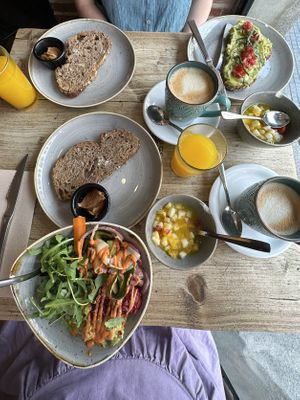 All vegan! Lattes with oat milk, orange juice, peanut butter toasts, fruit cups, and entrees of avocado toast and a vegan bowl 😋  at Mamúa in Madrid