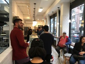 Line inside store, showing (limited) seating at Michaeli Bakery - Upper East Side in New York City