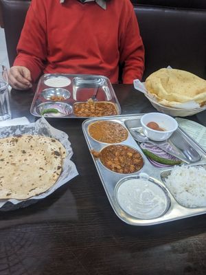 Dinner thali with black lentils and chickpea curry (front) chholay bhature plate (back right) at Satya Asha Veggie Food World in Surrey