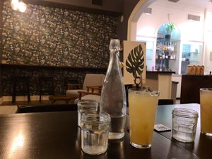 Bottled ice water and glass of house made rosemary lemonade. at Botanical Plant-Based Fare in Charlottesville
