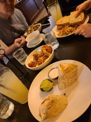 Breakfast burrito, chickpea tuna sandwich with curry rice, kale salad and in the center is a bowl of sticky cauliflower. at Botanical Plant-Based Fare in Charlottesville