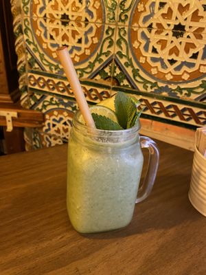 Green smoothie with fresh orange juice and frozen fruit   at Meet Vegano in Malaga