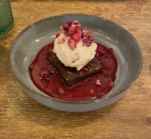 Brownie with strawberry-cheesecake ice cream and raspberry sauce.   at Meet Vegano in Malaga