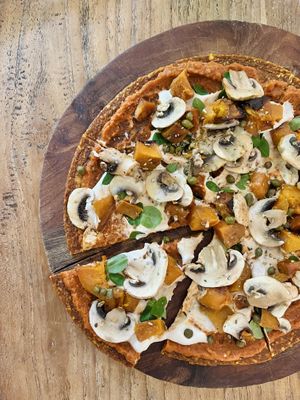 Pizza! Tasted great! Raw base, then tomato sauce, cheese, pumpkin, capers, mushrooms and herbs. Pretty sure the base had quite a long ingredient list which is unnecessary 🧐   at Alchemy in Ubud