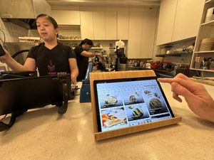 Digital menu on the counter and the small kitchen set up   at Mana Café in Manama