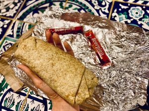 Integral grain tortilla filled with quinoa and vegan fillings, along with two packs of Scorpion sauce. at Tortilla Casa in Belgrade