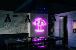Gorgeous pink neon illuminates the main restaurant. at Bonsai Plant Kitchen in Brighton