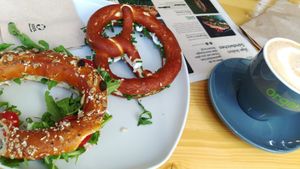 Mein Frühstück: Dinkelring mit Frischkäse, Tomaten und Rucola, Brezel mit Frischkäse und Schnittlauch und ein Cappuccino at Plänty Sandwiches in Munich