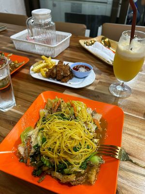 Yellow noodles with veggies and tofu and crispy fried “chicken" and fresh apple juice  at Reunion Cafe in Vientiane