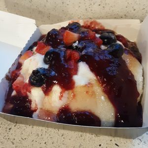 Very Berry Roll - crème brûlée frosting topped w/ strawberries, blueberries, raspberry jam, & powdered sugar at Cinnaholic in Des Moines