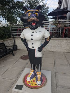 Outdoor seating area visible behind the pizza panther at Urban Pie in Cedar Falls