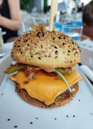 Vegan burger with vegan cheddar, grilled zucchini, salad, fried onions & something like a beyond burger patty at Le Sunset-Nice in Nice