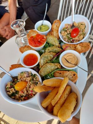 Vegan Tapas (for two people) with Tabbouleh and leafy salad, dumplings, marinated peppers, various dips, and something fried (bottom right). Not on the photo: small basket of white at Le Sunset-Nice in Nice