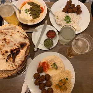 several dishes with pita bread and beer at Hummus Bar - Oktober in Budapest