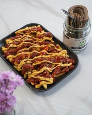 Salchizpapas - Sausage and loaded fries topped with Chiz Sauce and BBQ Sauce. at Sauce Tree Kuta in Kuta