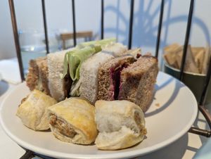 Cucumber + cream cheese, Seitan + lettuce + tomato, beetroot + hummus + crispy onion sandwiches, local handmade vegan sausage rolls. at Hamilton's Tea House in Farnham