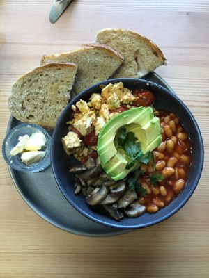 Brunchin’ bowl with avocado, tofu scramble, garlic mushrooms, balsamic tomatoes, baked beans and toast.  at Just My Cuppa' in Yeadon