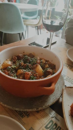 Patatas asadas y chorizo vegano ecológico gallego con queso vegano fundido y chimichurri at Distrito Vegano Invernadero in Madrid