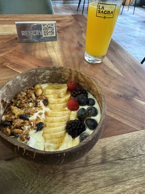 Yogurt bowl with orange juice   at Distrito Vegano Invernadero in Madrid