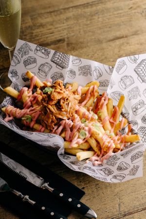 “PATATAS TENNESSEE”
French fries with BBQ Jackfruit meat on top and chives, a pink beet root garlic dressing adds a terrific touch!  at La Loncheria Bcn in Barcelona