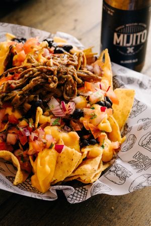 “NACHOS DELUX”
Made with fresh corn tortilla chips, black beans, pico de gallo sauce, an incredible vegan cheese and a vegan banana peel meat on top! Yes, you read right! 😍 at La Loncheria Bcn in Barcelona