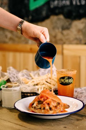 “LA TORTA AHOGADA”
Mexican typical sandwich, filled with fried heura chunks and black beans, dipped in a hot tomato sauce and red onion on top. You will not find it in anywher at La Loncheria Bcn in Barcelona