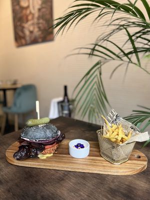 Black charcoal burger bun with jackfruit , salad and chips   at Puravita Vegan  in Estepona