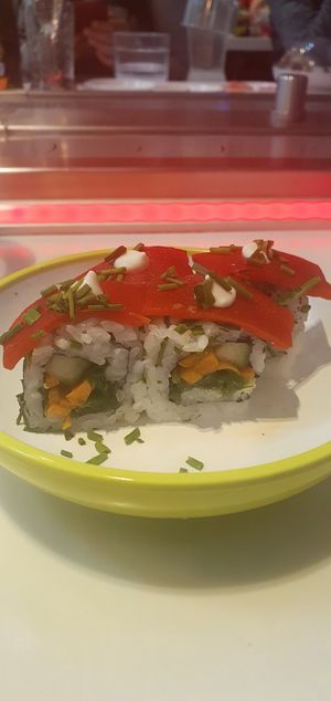 Red pepper dragon roll: Kaiso, cucumber, carrot & chive roll, topped with sweet roasted red pepper. Garnished with mayo & chives (ve) at Yo! Sushi - Trafford in Manchester