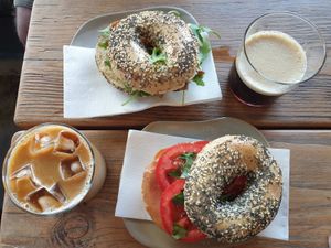 Iced latte $7.00, Hummus, Caramalised Onion+Rocket everything bagel $12.00, Nitro Coffee $7.00, Ham, Tomato+Basil everything bagel $12.00 at CBCB & ODFUB in Brunswick