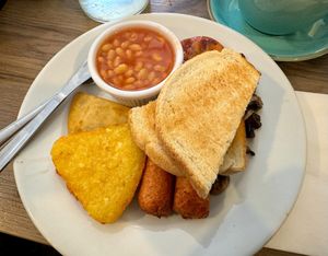 Full vegan breakfast, including potato bread, hash browns, baked beans, vegan sausages, mushrooms and a grilled tomato at Snax Cafe in Edinburgh
