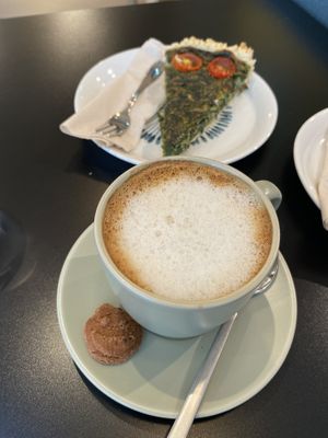 Flat white with chocolate/orange biscuit  at LUSH Cafe in Munich
