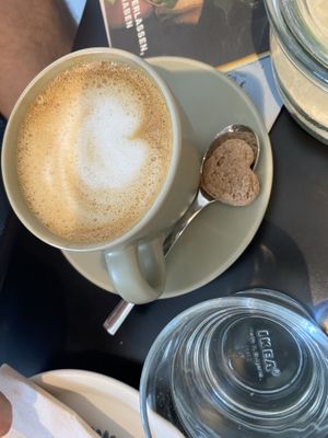 Oat cappuccino with accompanying biscuit  at LUSH Cafe in Munich