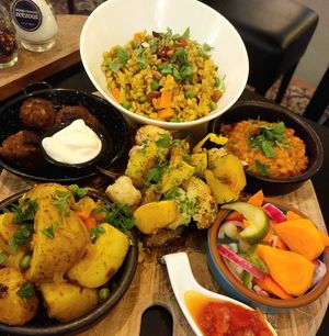 Indian style main for 2 persons. On the left meat balls for the non-vegan, on the right a bland Dahl (to share) as the vegan alternative. Having a special vegan snack (maybe samosa at FoodVia in Arnhem