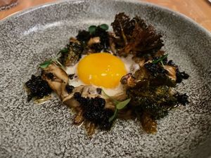 Gebakken maitake paddenstoel | kastanjeschuim | XO-paddenstoelensaus | 63 graden eidooier | gefrituurde flower sprouts  at Flow Yoga & Food in Delft