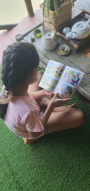 Kid reading free book at Quoc Linh Eco Village Retreat in Hoi An