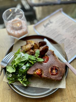 The wall board features daily specials. Tomato & courgette quiche with Greek lemon roasted potatoes and salad leaves with a basil dressing   at VIBE Plant Based Cafe & Restaurant in Douglas