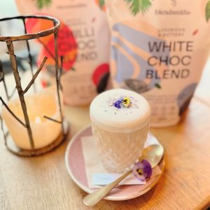 Blendsmiths dreamy white hot chocolate made with oat milk and garnished with edible dry and fresh flowers from the roof garden  at VIBE Plant Based Cafe & Restaurant in Douglas