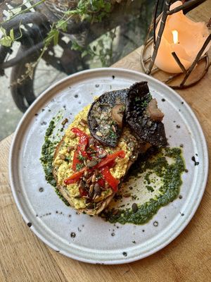 Door stop toast topped with Mediterranean Scrambled tofu, herb roasted mushrooms, sweet red peppers, Zhoug & soy roasted seeds   at VIBE Plant Based Cafe & Restaurant in Douglas