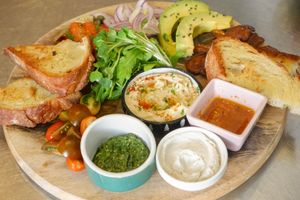 Vegan Appertiser Platter, a big vegan dish for 2 people with home-made bread, vegan bacon, vegan smoked salmon, hummus, cream cheese, pesto, rocket, cherry tomato, avocado. at Moto Laurie in Da Lat