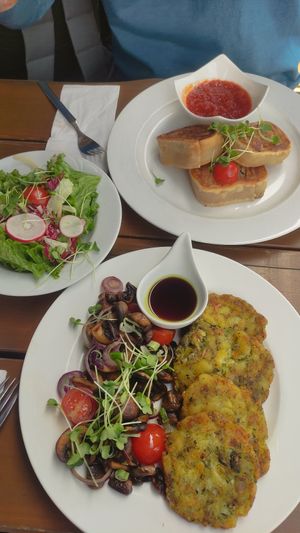 Unten Kürbiskernrösti mit gebratenen Pilzen und Kürbiskernöl, oben Krautkrapfen mit Tomatensud und gemischten Salat at Hündle Berggaststätte in Oberstaufen