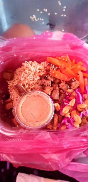 Peanut bowl in a takeaway box with sauce on the side at IRIE in San Juan Del Sur