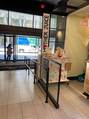 Side entrance, sign, and menu/napkin/cutlery station.  at Mother Juice - High St Place in Boston