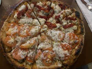 Half primavera caribeña and half sun dried Cozumel   at Coral Vegan Pizza in Playa Del Carmen