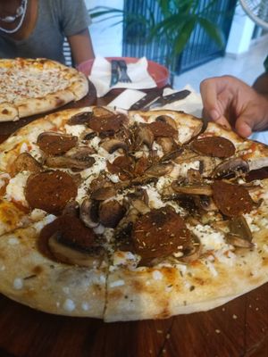 Pizza with pepperoni and mushrooms at Coral Vegan Pizza in Playa Del Carmen