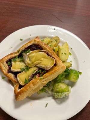 Filo parcel with melted vegan Camembert and caramelised beetroot on green veg and new potatoes.  at Eat To The Beat in Aylesbury