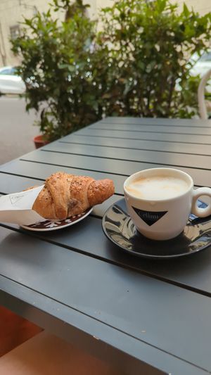Cappuccino and a croissant with blueberry filling  at Arcadia Caffe in Pisa