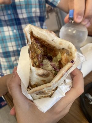 Lahmacun Linsen: giant flat bread smeared with lentil, topped with red cabbage, onion mixture, vegan yogurt, cucumbers, tomatoes, fresh squeezed lemon & wrapped up to eat!  at Köstlich Vegan in Tubingen