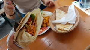 Falafel wrap and non-vegan platter in background at Imbiss Beirut in Stuttgart