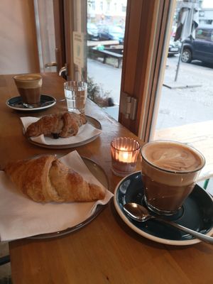Oat flat whites, choc croissant foreground, jam background at Croissanterie in Berlin