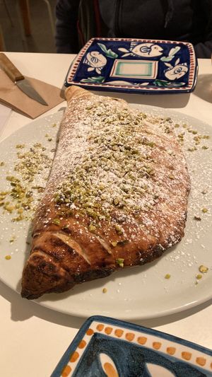 Fried Calzone filled with vegan hazelnut creme, powdered sugar and pistachio sprinkles. at Al Catzone Pizza Napovegana in Berlin